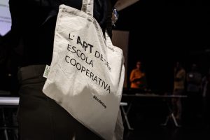 Bossa amb el lema l'art de ser escola cooperativa.